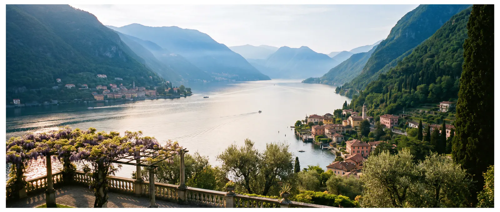 Le lac de Côme depuis une terrasse le matin, glycine au premier plan et villages le long de la rive.